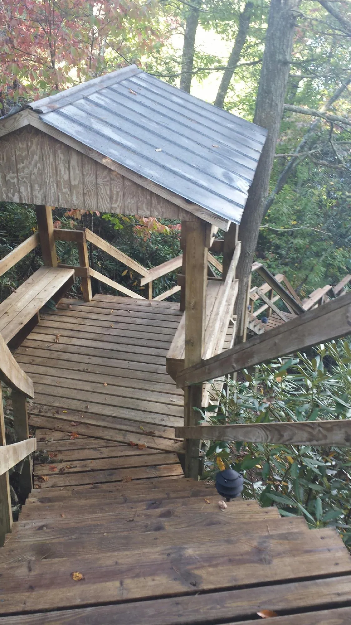 Metal roofed shelter over wooden steps on a wooded walkway — Skylight Repair & Installation work by our crew in Sykesville