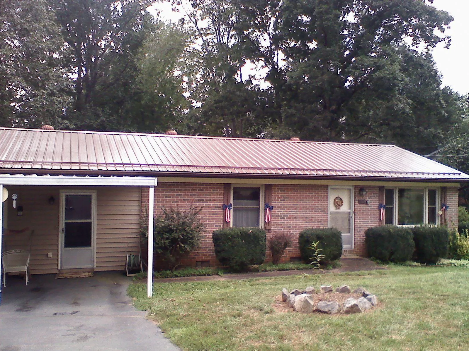 Bronze metal roof and carport on a brick ranch home — Roof Repair work by our crew in Sykesville